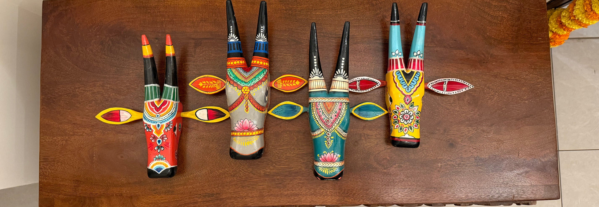 Colorful horned figurines on a wooden table