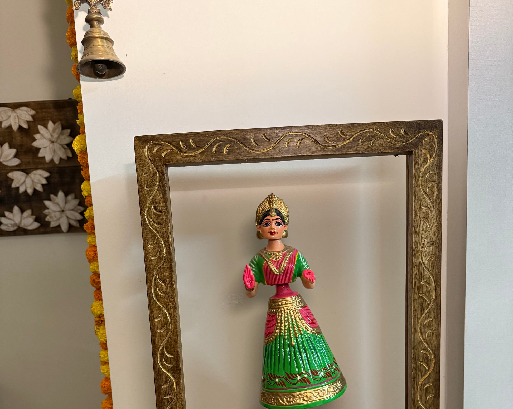 Decorative figurine in a gold frame on a white surface